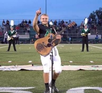 Because no one wanted to sing the national anthem, one high school kid removed his helmet and picked up a guitar.